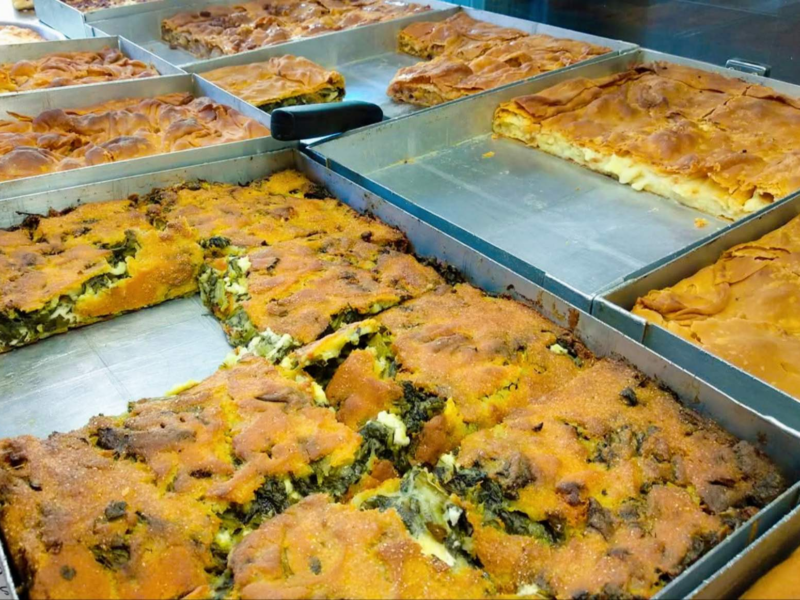 Variety of savory pies and pastries displayed in metal trays