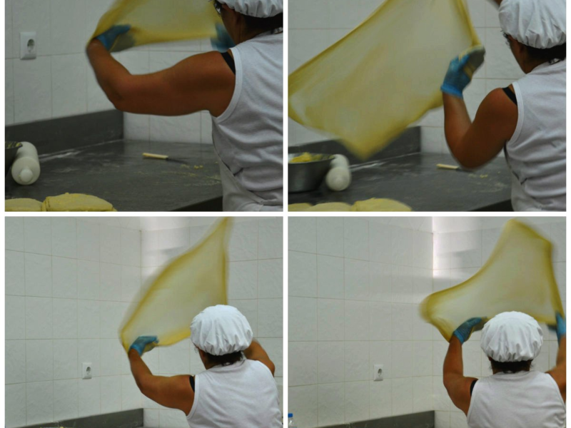 Woman stretching dough in a professional kitchen