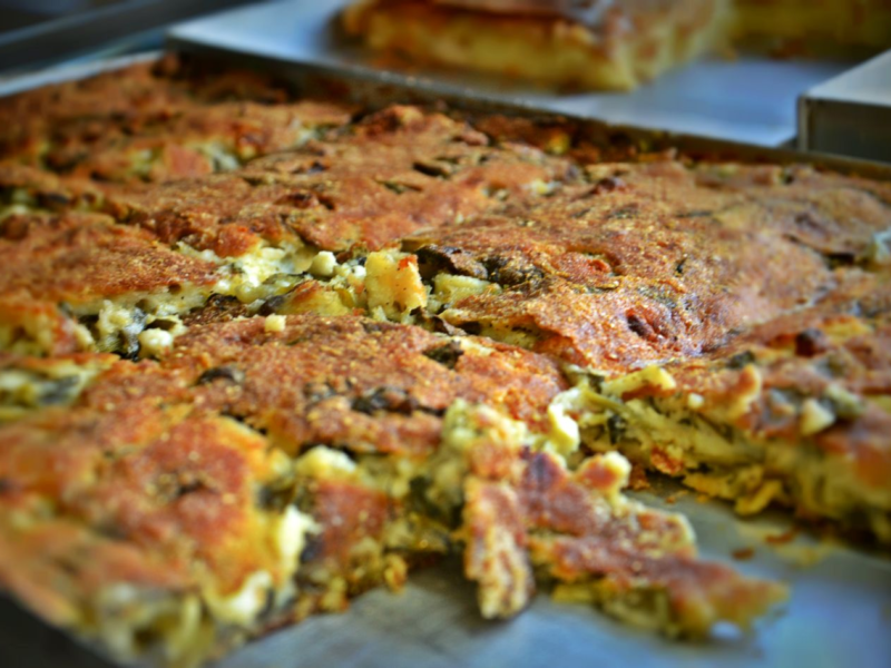 Close-up of a savory pie with a golden crust, sliced and ready to serve.